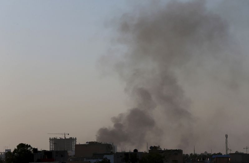 © Reuters. Black smoke raises into the air near Benghazi port, where there are violent clashes, in Benghazi