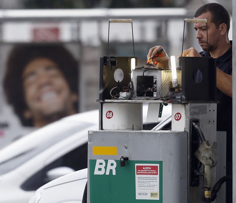 © Reuters. A man works on a gasoline pump at a petrol station in Diadema