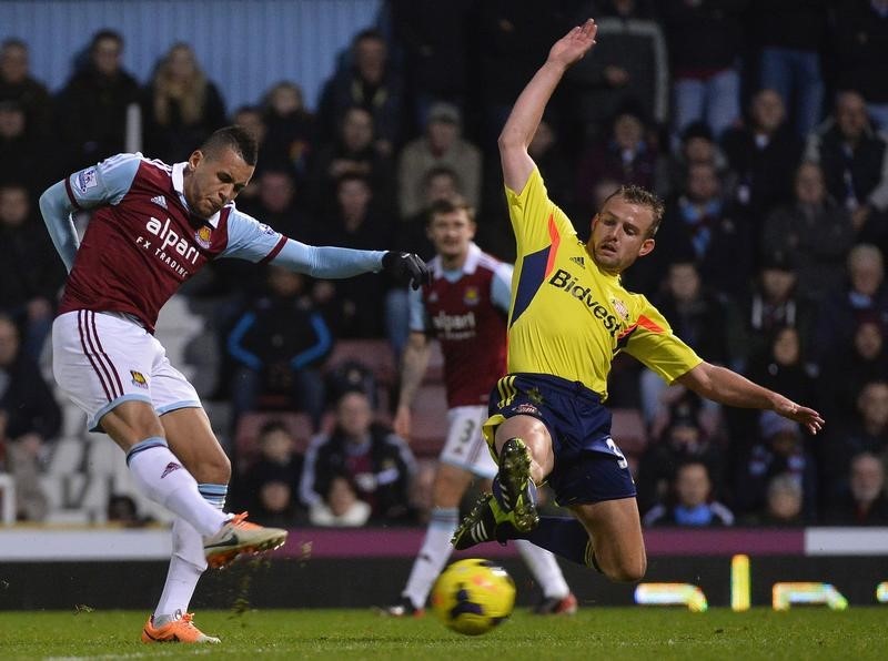 © Reuters. West Ham United's Morrison shoots on goal as Sunderland's Cattermole attempts to block the attempt during their English Premier League soccer match in London