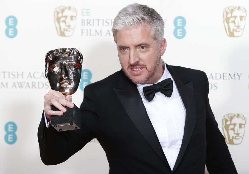 © Reuters. McCarten celebrates after winning best adapted screenplay for "The Theory of Everything" at the BAFTA awards in London