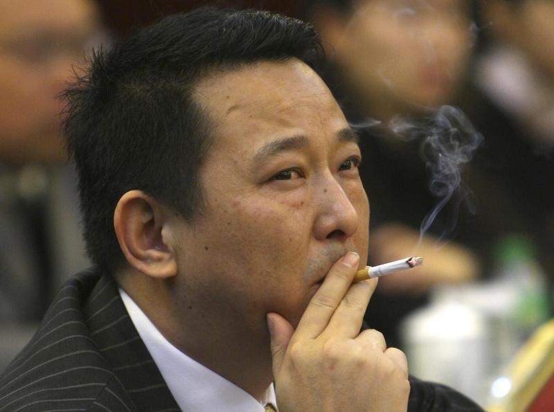 © Reuters. Liu Han, former chairman of Hanlong Mining, smokes a cigarette during a conference in Mianyang