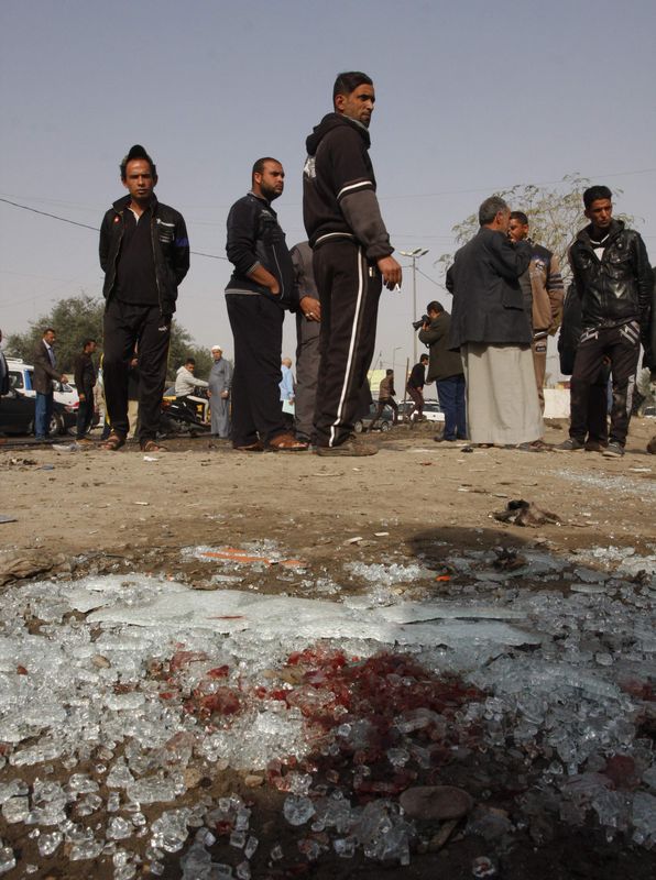 © Reuters. Pessoas observam local de explosão de bomba em Kadhimiya, em Bagdá