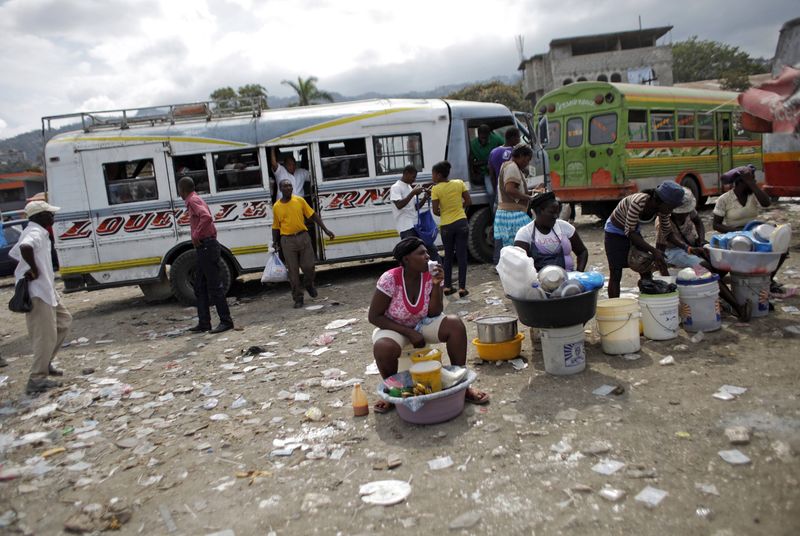 © Reuters. Women offer food for sale at a bus station in Port-au-Prince