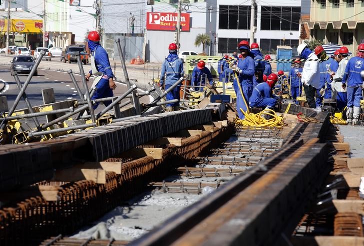 © Reuters. Operários trabalham em construção em Cuiabá antes da Copa