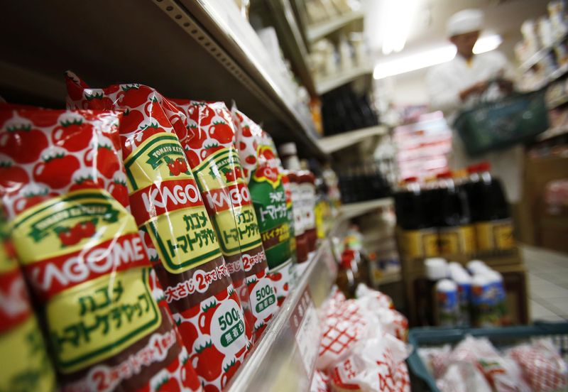 © Reuters. Kagome's tomato ketchup bottles are displayed next to tomato ketchups of other brands as a shopper walks by, at Yoshiike supermarket in Tokyo