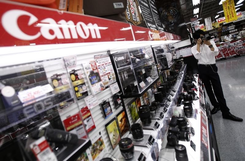 © Reuters. Man tries a Canon digital camera at an electronics retail store in Tokyo