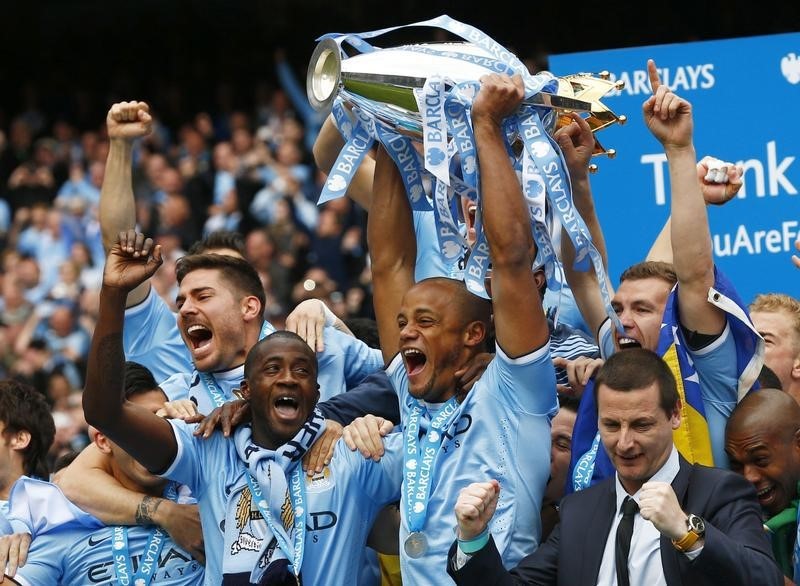 © Reuters. Manchester City's captain Vincent Kompany celebrates after winning the English Premier League trophy following their soccer match against West Ham United