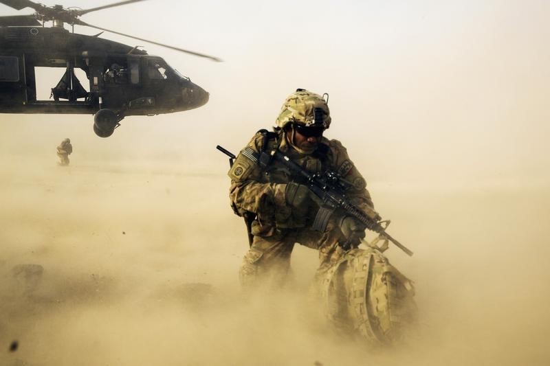 © Reuters. A U.S. soldier from the 3rd Cavalry Regiment shields himself from the rotor wash of a UH-60 Blackhawk helicopter after being dropped off for a mission with the Afghan police near Jalalabad