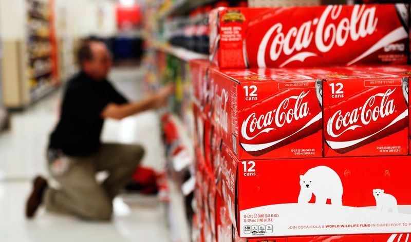 © Reuters. An employee arranges bottles of Coca-Cola at a store in Alexandria in this file photo