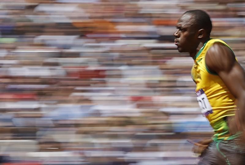 © Reuters. Usain Bolt of Jamaica runs on his way to winning his 100m heat round 1 during the London 2012 Olympic Games at the Olympic Stadium