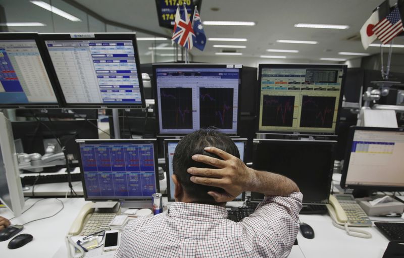 © Reuters. An employee of a foreign exchange trading company works in front of monitors in Tokyo