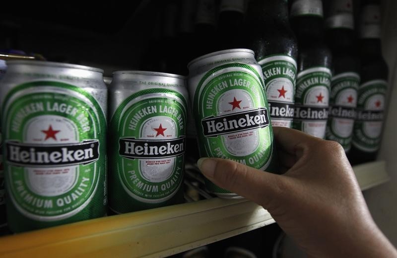 © Reuters. Woman reaches for a can of Heineken at a restaurant in Bangkok