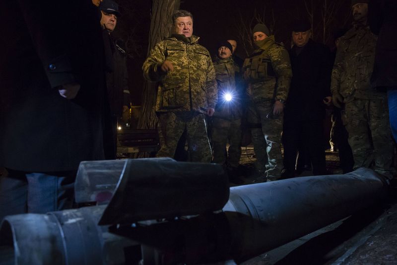 © Reuters. Ukrainian President Petro Poroshenko points at the remains of ammunition during a visit to Kramatorsk