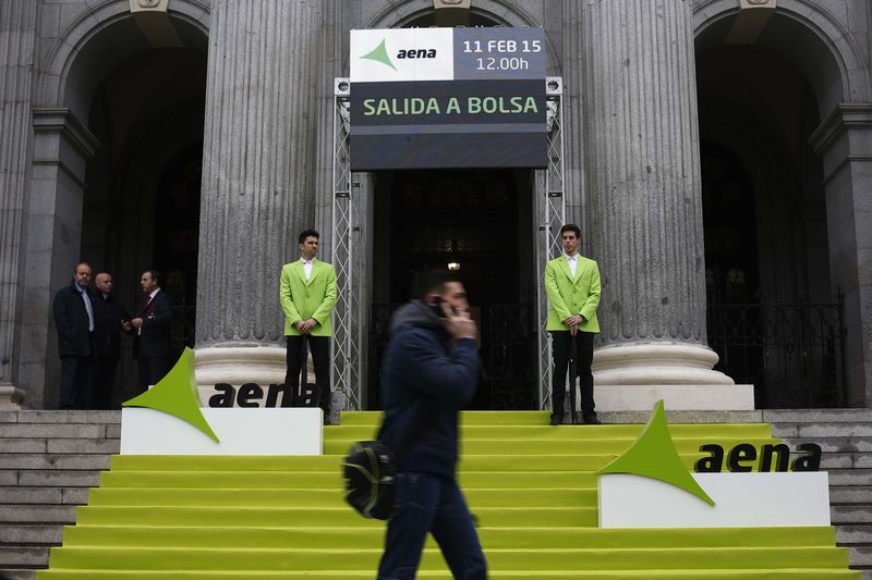 © Reuters. A man walks past Madrid's bourse during the stock market debut of the Spanish airports group Aena