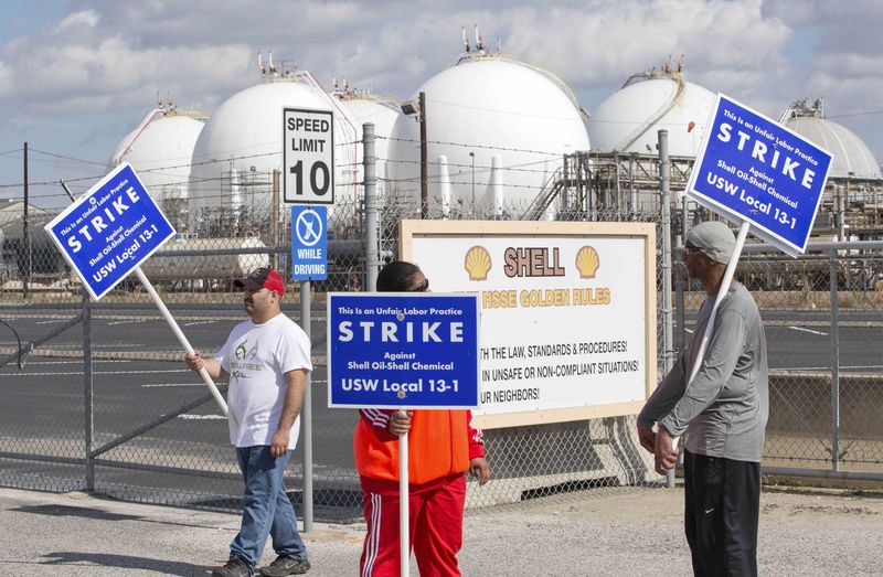 © Reuters. Workers from the USW union walk a picket line outside the Shell Oil Deer Park Refinery in Deer Park, Texas