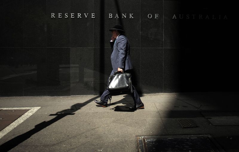 © Reuters. File photo of a Sydney businessman walking into the light outside the Reserve Bank of Australia