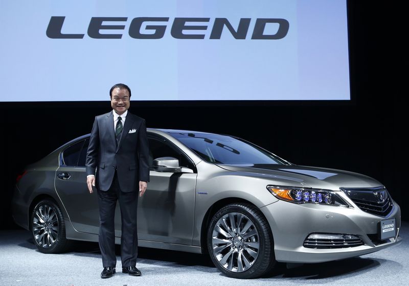 © Reuters. File photo of Honda Motor Co's President and Chief Executive Officer Ito posing for photos with renewal hybrid sedan car "Legend" during an unveiling event in Tokyo