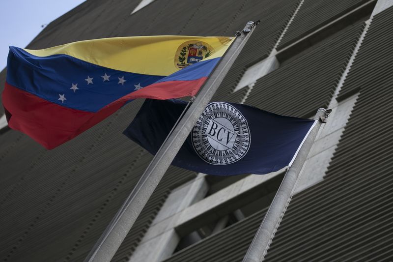 © Reuters. Flags of Venezuela (L) and the Central Bank are seen at the central bank building in Caracas