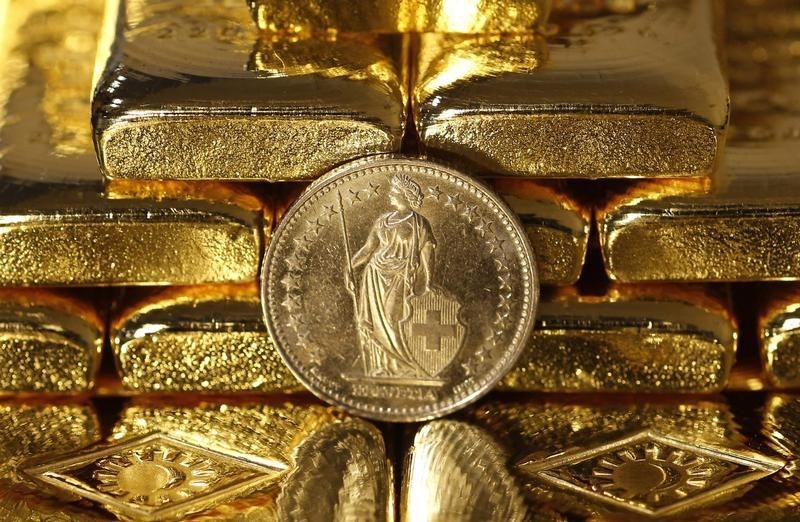 © Reuters. Gold bars and a Swiss Franc coin are seen in this illustration picture in Vienna