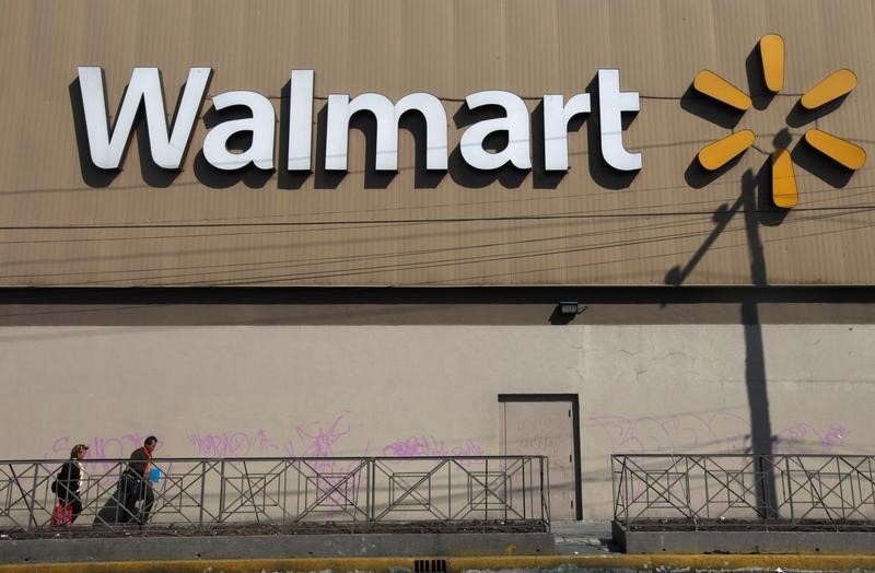 © Reuters. Two people walk outside a Wal-Mart store in Mexico City