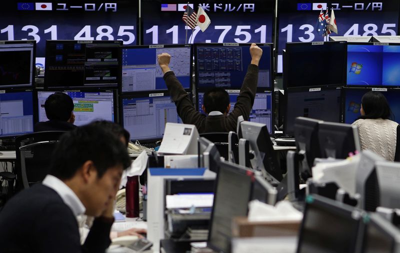 © Reuters. An employee of a foreign exchange trading company stretches in front of monitors in Tokyo