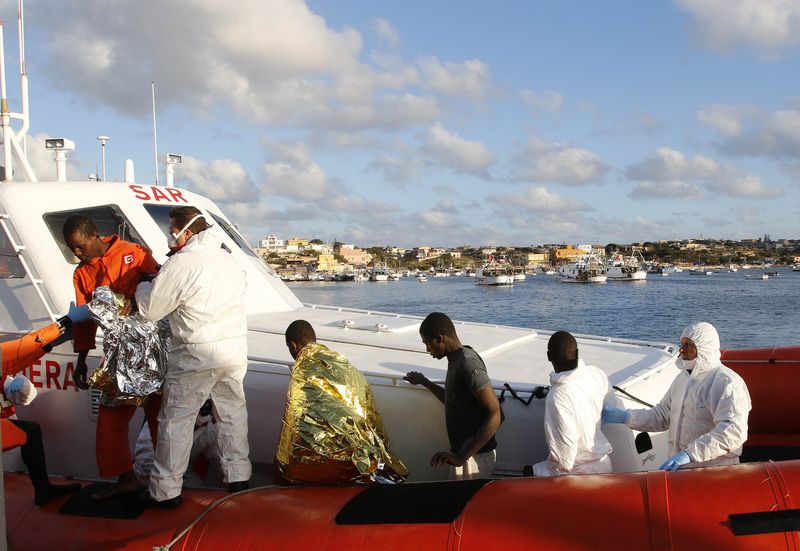 © Reuters. Imigrantes resgatados no mar pela guarda costeira da Itália chegam à ilha de Lampedusa