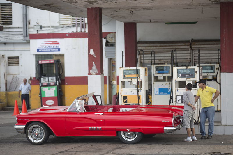 © Reuters. Carro vintage é abastecido em posto de combustível na orla de Havana