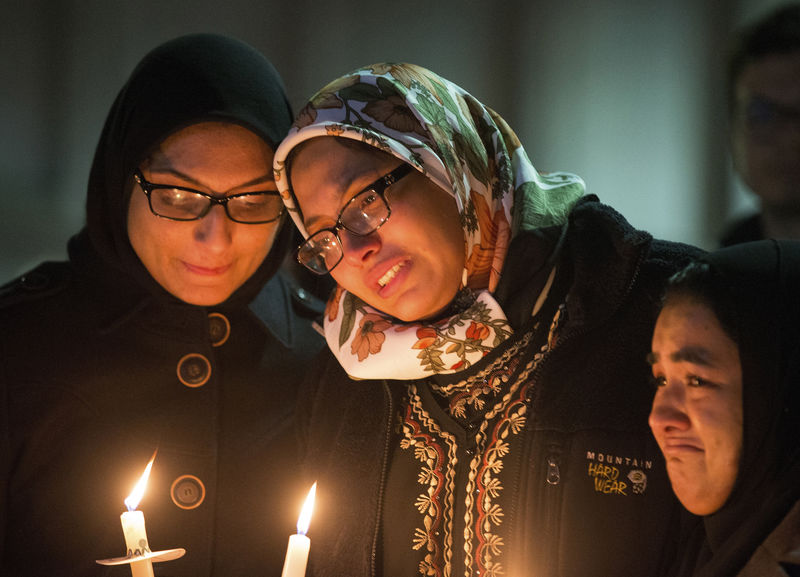 © Reuters. Students with lit candles attend a vigil on the campus of the University of North Carolina, for the three young Muslims who were killed in Chapel Hill