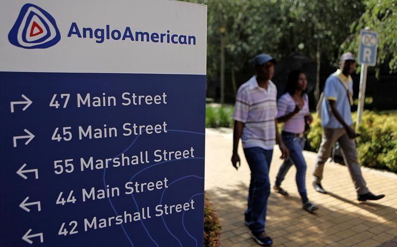 © Reuters. People walk past a board outside the Anglo American offices in Johannesburg