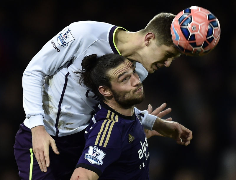 © Reuters. West Ham United's Carroll challenges Everton's Stones during their FA Cup third round replay soccer match in London