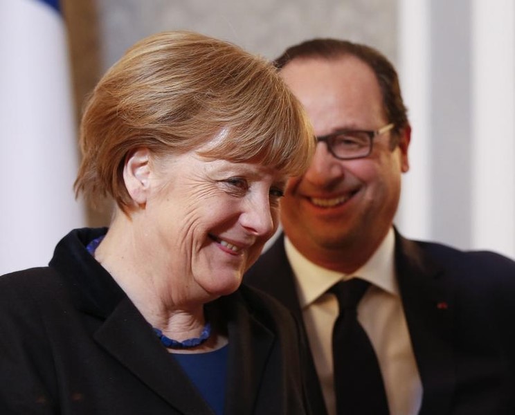 © Reuters. Germany's Chancellor Merkel and France's President Hollande smile after taking part in peace talks on resolving the Ukrainian crisis in Minsk