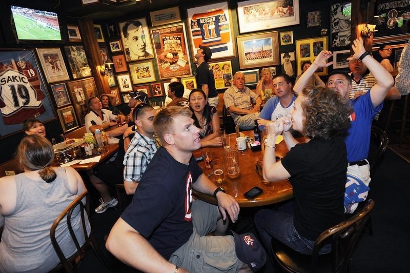 © Reuters. Fans react as they watch the 2010 World Cup soccer match between the U.S. and England via television from South Africa, at Bugsy's Sports Bar in Alexandria, Virginia