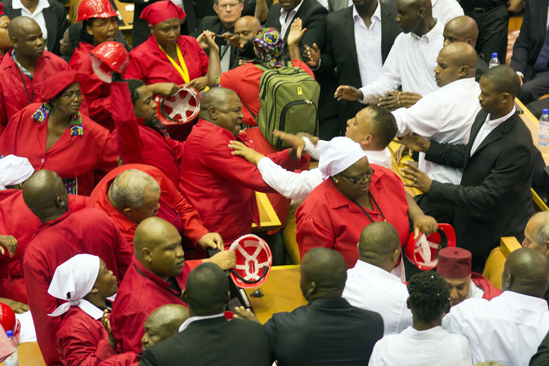 © Reuters. Members of Julius Malema's Economic Freedom Fighters (EFF) (in red) clash with security officials after being ordered out of the chamber during President Jacob Zuma's State of the Nation address in Cape Town