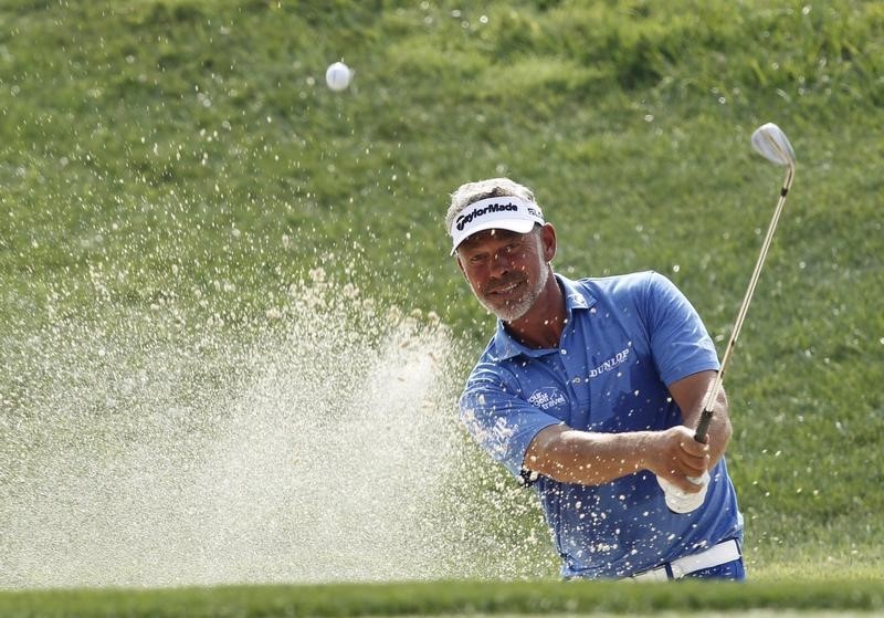 © Reuters. Clarke of Northern Ireland chips onto the 17th green during the third day of practice for the 96th PGA Championship at Valhalla Golf Club in Louisville