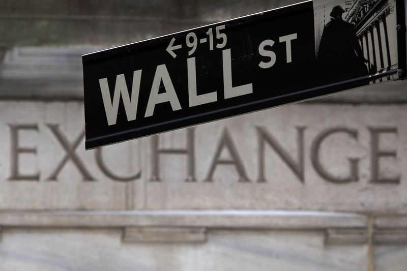 © Reuters. A Wall Street sign is pictured in front of the New York Stock Exchange, open during Winter Storm Juno, in the Manhattan borough of New York