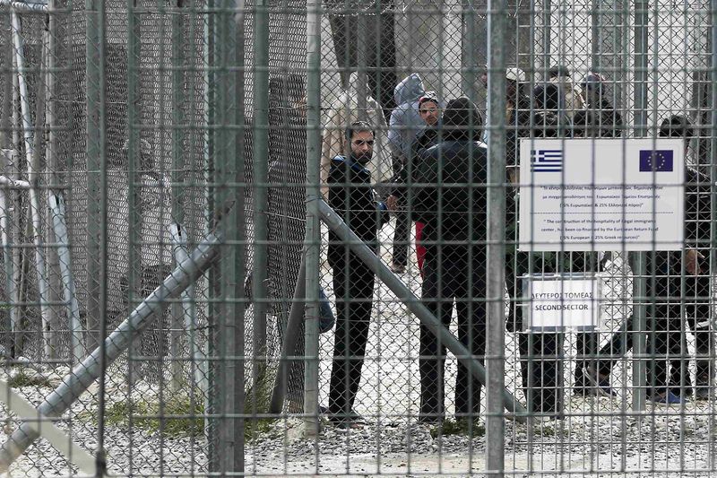 © Reuters. mmigrants stand behind a fence at a detention centre in the Amygdaleza suburb of western Athens