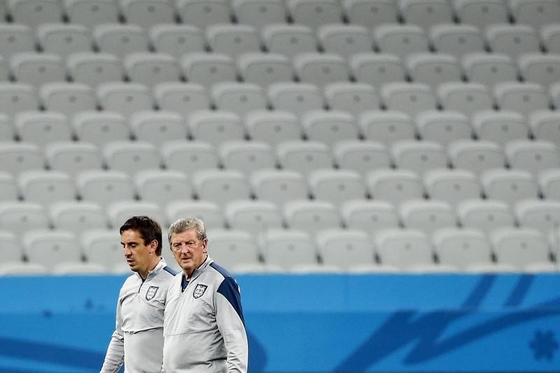 © Reuters. England's national soccer team coach Hodgson and assistant coach Neville wait for players to come out for their practice in Sao Paulo