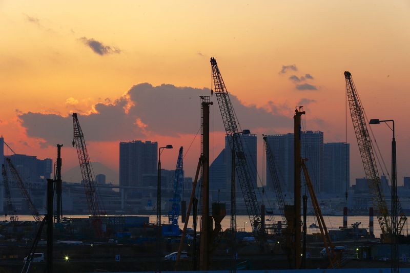 © Reuters. Cranes are pictures against sunset at a construction site in Tokyo