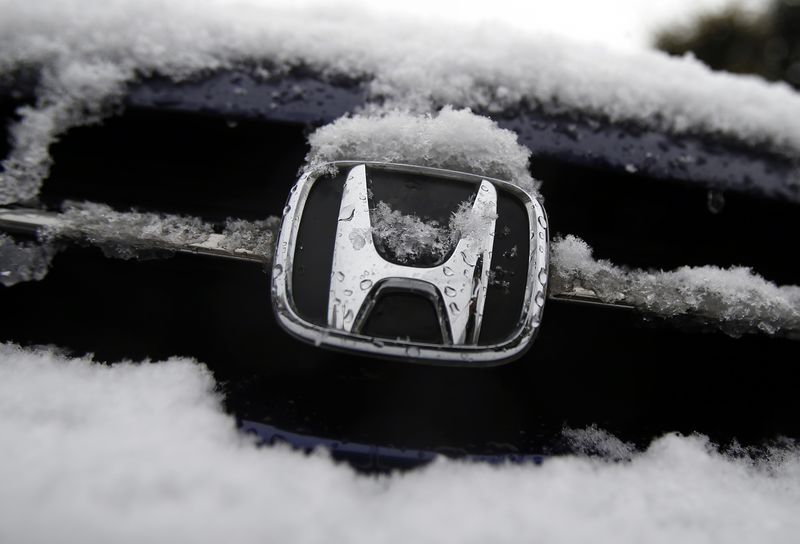 © Reuters. A logo of Honda Motor Co covered by snow is seen on a car parked on a street in Tokyo