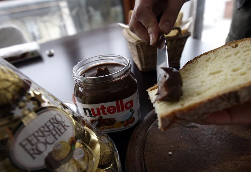 © Reuters. A woman spreads Nutella on a slice of bread in Milan