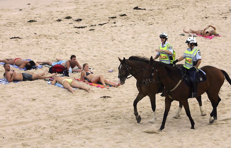 © Reuters. File photo of mounted police passing sunbathers on North Cronulla Beach in Sydney