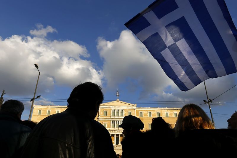 © Reuters. People are silhouetted as a Greek national flag flutters as during an anti-austerity pro-government demo in front of the parliament in Athens