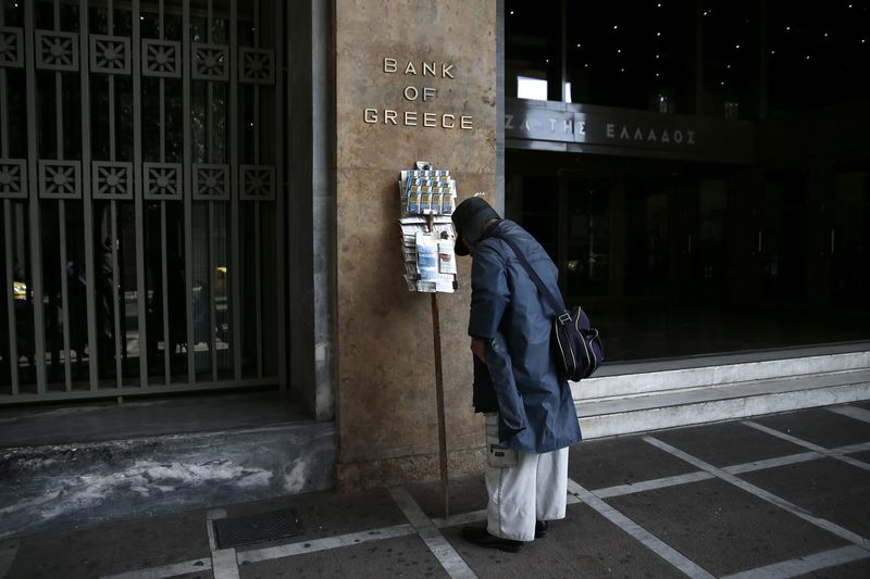 © Reuters. Um vendedor de bilhetes de loterias parado em frente à sede do banco central grego, em Atenas