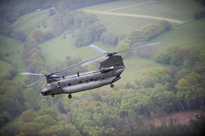 © Reuters. Royal Air Force Chinook helicopter flies in formation above RAF Odiham in Hampshire during rehearsal for Saturday's Diamond Jubilee flypast over Windsor Castle