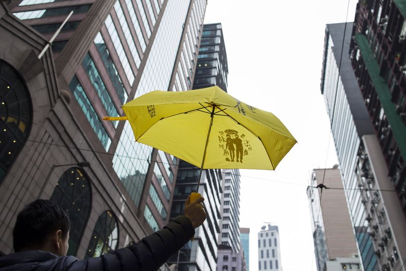 © Reuters. A pro-democracy protester holds up a yellow umbrella, which is the symbol of the Occupy Central movement, during a march in the streets to demand universal suffrage in Hong Kong