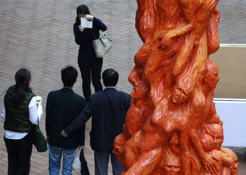 © Reuters. Visitors pose in front of the "Pillar of Shame"  inside the campus of the University of Hong Kong
