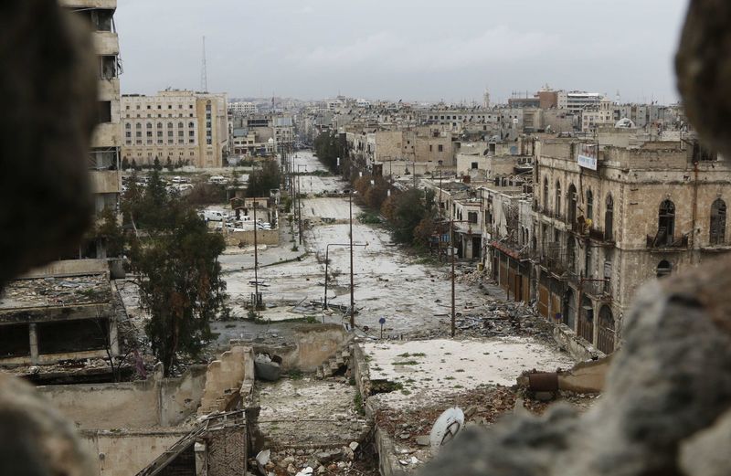 © Reuters. A general view shows damaged buildings along a deserted street and an area controlled by forces loyal to Syria's President Assad, as seen from a rebel-controlled area at the Bab al-Nasr frontline in Aleppo