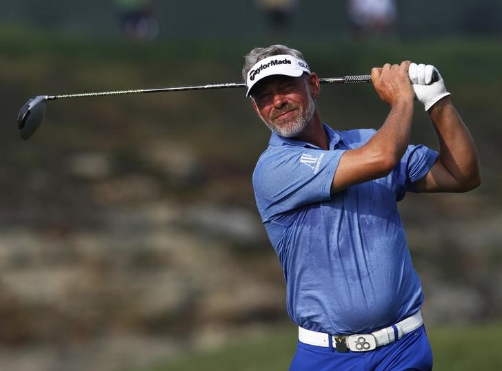 © Reuters. Clarke of Northern Ireland tees off on the 15th tee during the third day of practice for the 96th PGA Championship at Valhalla Golf Club in Louisville