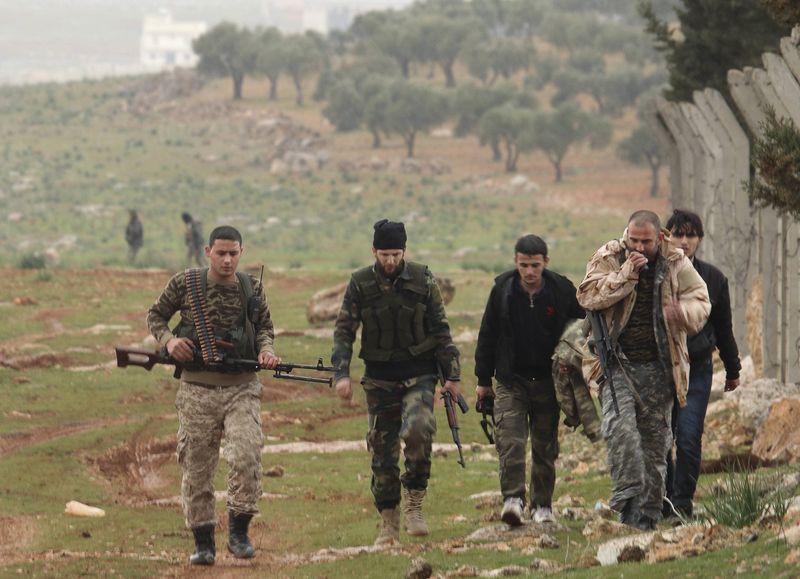 © Reuters. Rebeldes carregando armas enquanto vão em direção ao norte de Aleppo