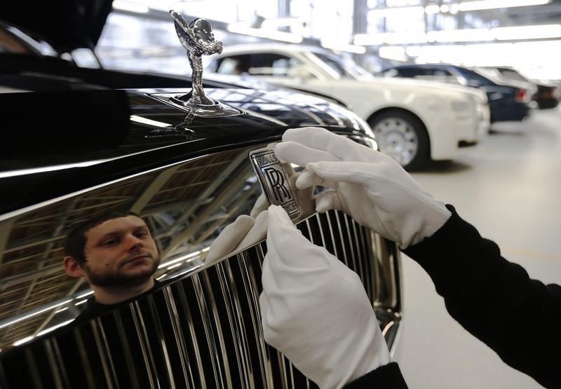 © Reuters. Employee Jamie Bedford attaches the logo badge to a Rolls Royce Ghost at the Rolls Royce Motor Cars factory at Goodwood